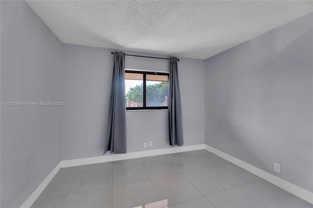 empty room featuring tile patterned flooring and a textured ceiling