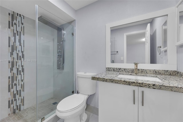 bathroom featuring an enclosed shower, vanity, and toilet