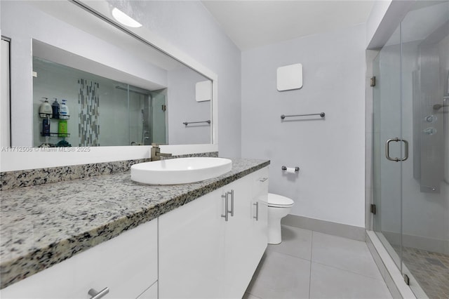 bathroom with toilet, vanity, tile patterned floors, and a shower with shower door