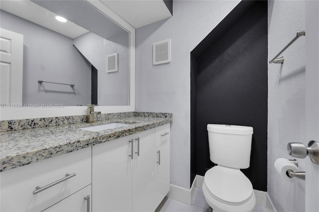 bathroom featuring tile patterned floors, vanity, and toilet