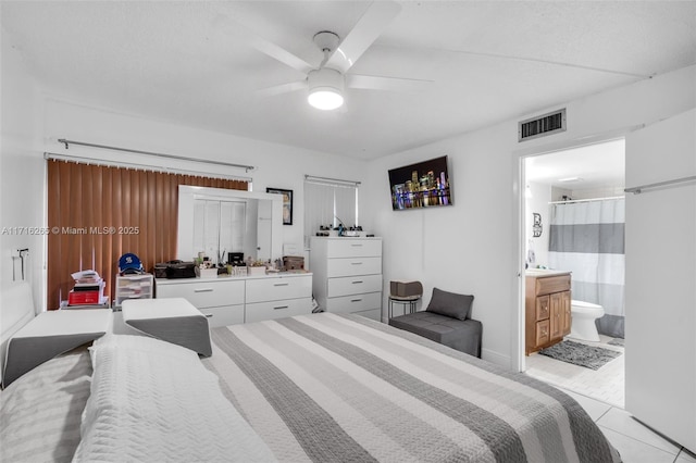 bedroom featuring light tile patterned floors, ensuite bath, and ceiling fan