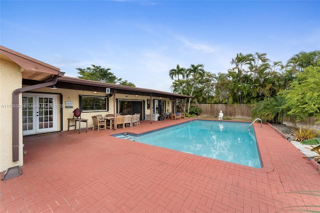 view of swimming pool featuring a patio area and french doors