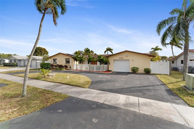 ranch-style home with a garage and a front lawn