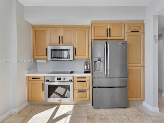 kitchen featuring appliances with stainless steel finishes, light brown cabinets, and light tile patterned floors