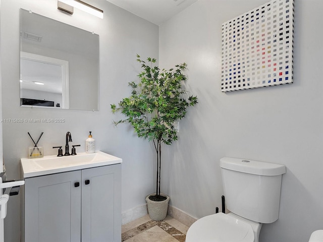 bathroom with toilet, vanity, and tile patterned floors