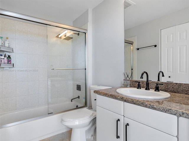 full bathroom featuring tile patterned floors, vanity, toilet, and shower / bath combination with glass door