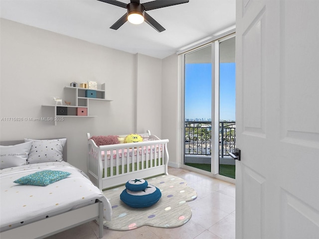 bedroom with ceiling fan, light tile patterned flooring, a wall of windows, and access to outside