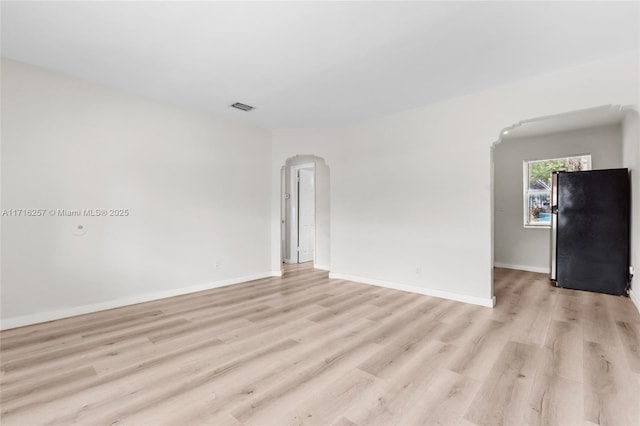 empty room with light hardwood / wood-style flooring