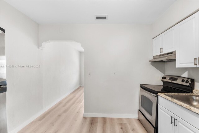 kitchen featuring white cabinetry, light wood-type flooring, and electric stove