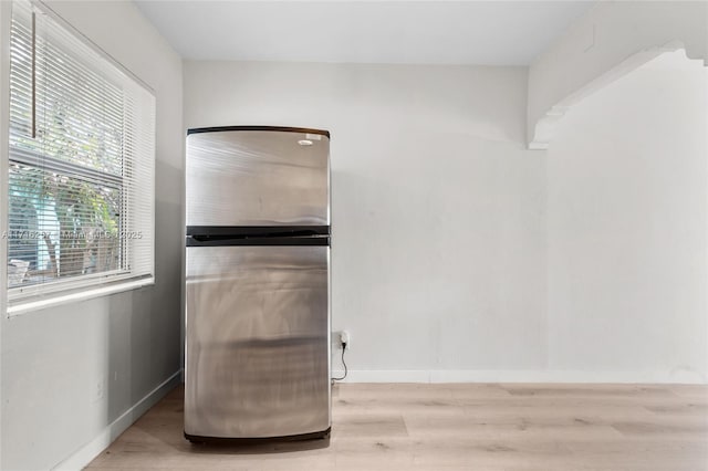 interior space with hardwood / wood-style flooring and stainless steel fridge