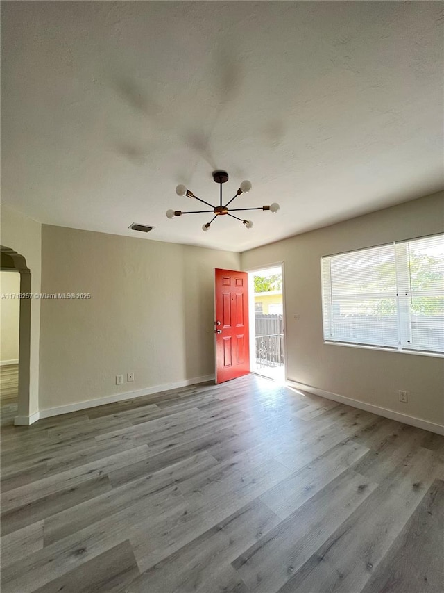 empty room featuring light hardwood / wood-style floors and an inviting chandelier