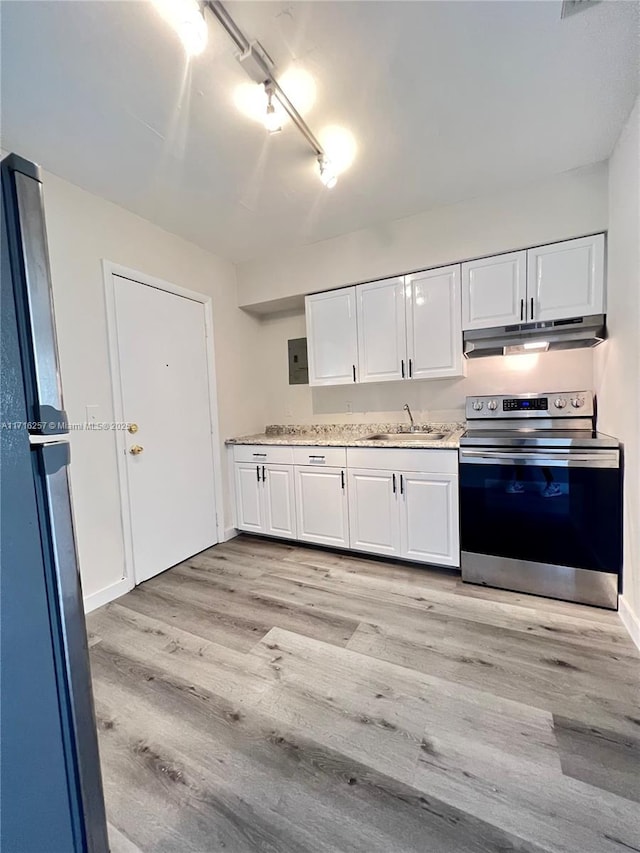 kitchen with white cabinets, light wood-type flooring, stainless steel appliances, and track lighting