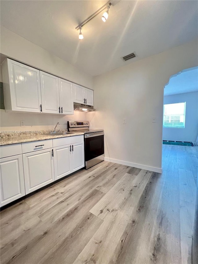 kitchen featuring white cabinets, electric stove, rail lighting, sink, and light hardwood / wood-style flooring