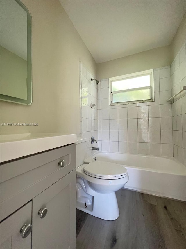 full bathroom featuring wood-type flooring, vanity, toilet, and tiled shower / bath