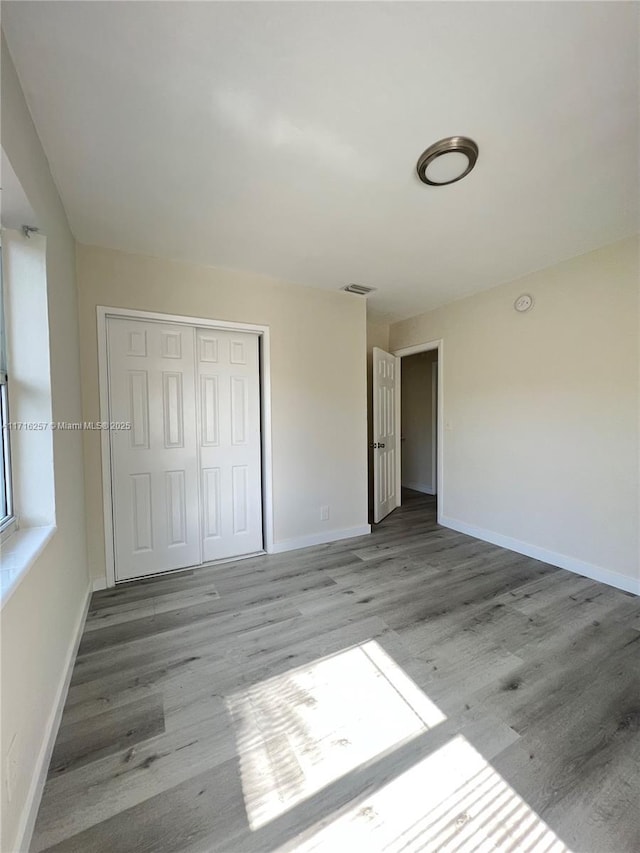 unfurnished bedroom featuring light hardwood / wood-style flooring and a closet