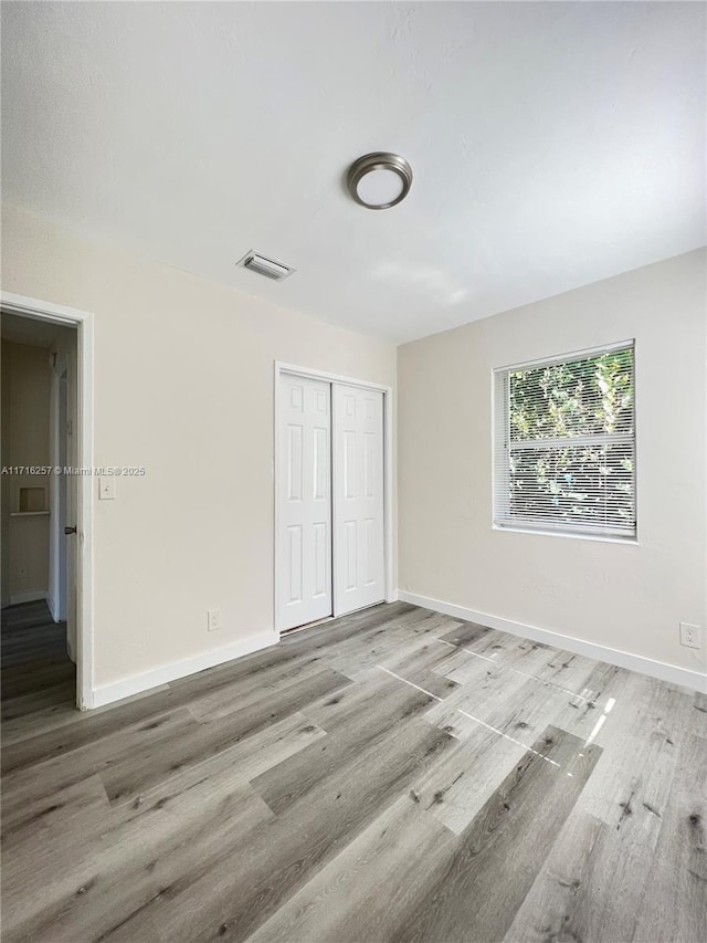 unfurnished bedroom with hardwood / wood-style floors and a closet