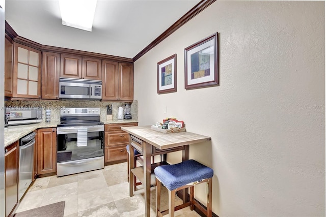 kitchen featuring backsplash, light stone countertops, ornamental molding, light tile patterned flooring, and stainless steel appliances