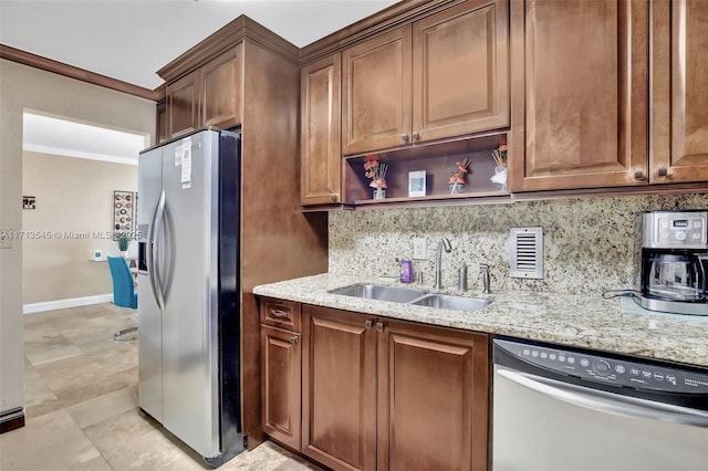 kitchen featuring light stone countertops, appliances with stainless steel finishes, backsplash, ornamental molding, and sink