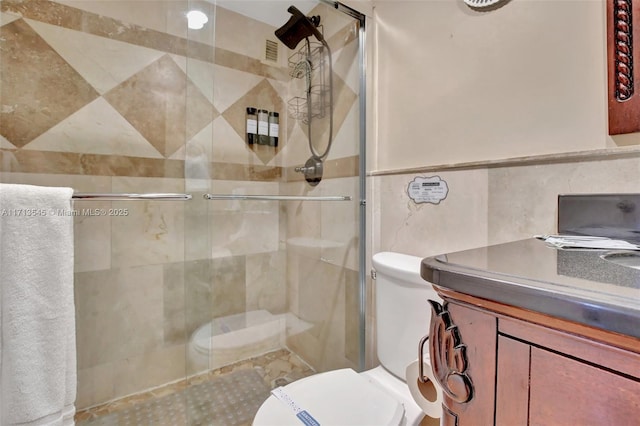 bathroom featuring an enclosed shower, tile walls, and toilet