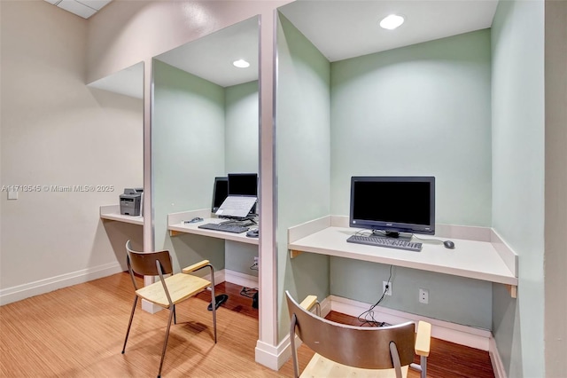 home office with light hardwood / wood-style floors and built in desk