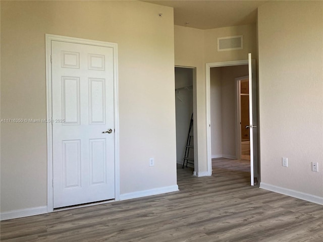 unfurnished bedroom with hardwood / wood-style flooring and a closet