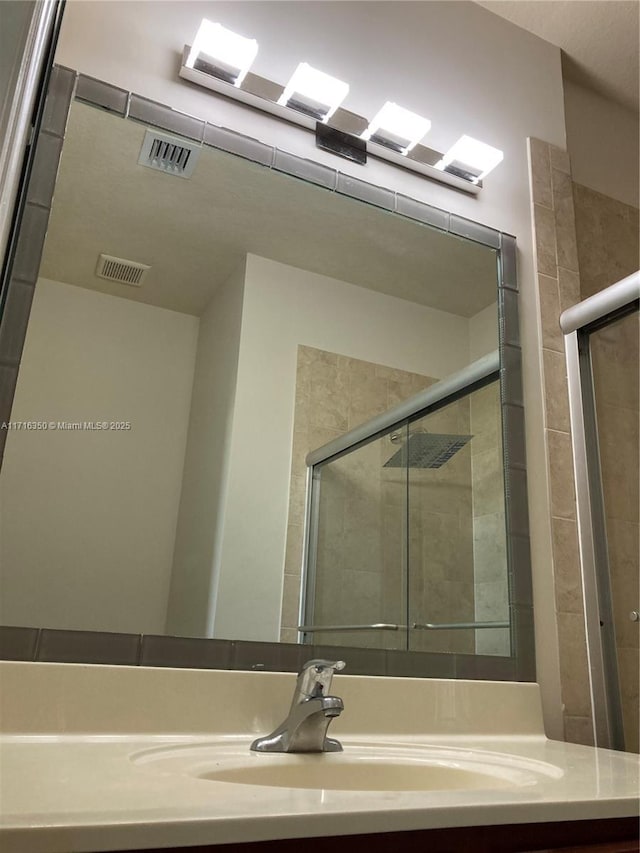 bathroom featuring vanity and a shower with door