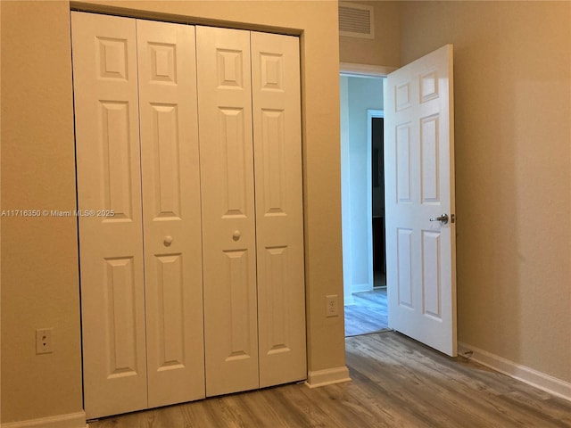 unfurnished bedroom with hardwood / wood-style floors and a closet