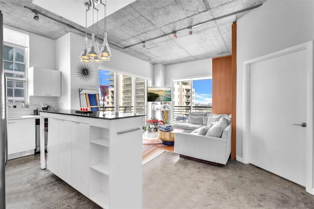 kitchen featuring white cabinets, track lighting, hanging light fixtures, and an inviting chandelier