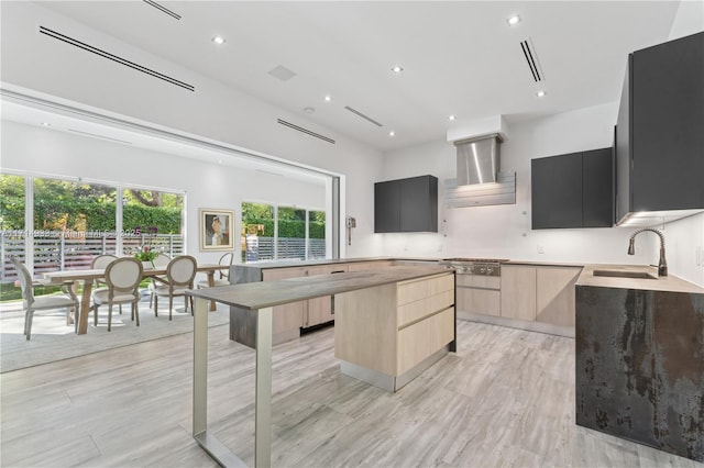 kitchen with light brown cabinets, a center island, exhaust hood, modern cabinets, and a sink