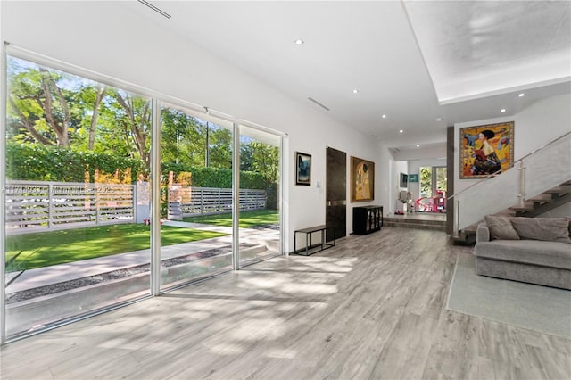 interior space featuring recessed lighting, stairway, a healthy amount of sunlight, and wood finished floors