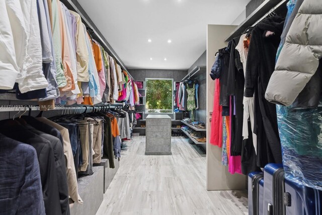 walk in closet with wood finished floors