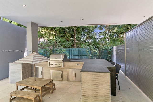 view of patio with a fenced backyard, grilling area, outdoor dining area, and an outdoor kitchen