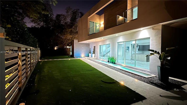 yard at night featuring fence
