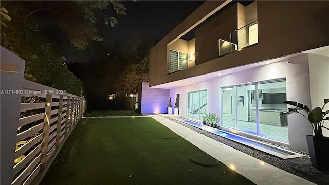 pool at twilight with a lawn and fence