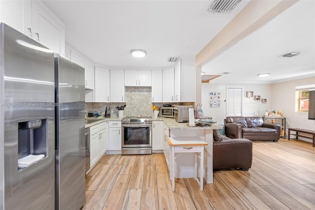 kitchen with white cabinetry, light stone countertops, stainless steel appliances, tasteful backsplash, and light hardwood / wood-style floors