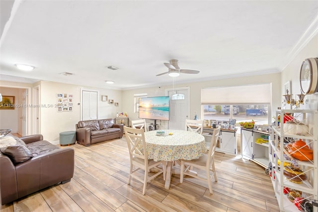 dining space featuring ceiling fan and crown molding