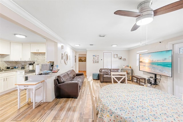 living room featuring ceiling fan, ornamental molding, and light hardwood / wood-style flooring