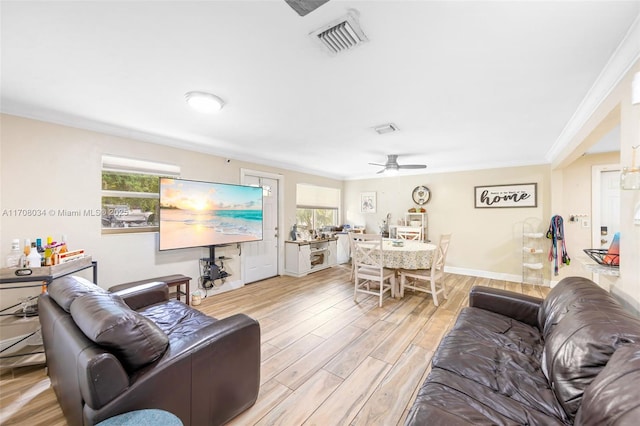 living room featuring ceiling fan and crown molding