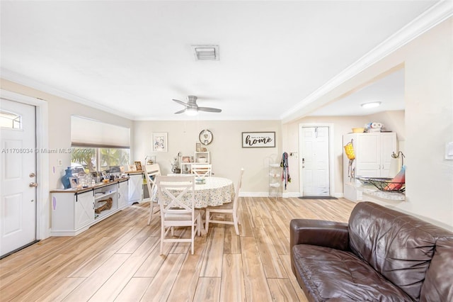 dining space with ceiling fan, crown molding, and light hardwood / wood-style floors