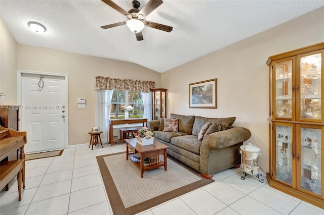 tiled living room featuring ceiling fan, vaulted ceiling, and a textured ceiling