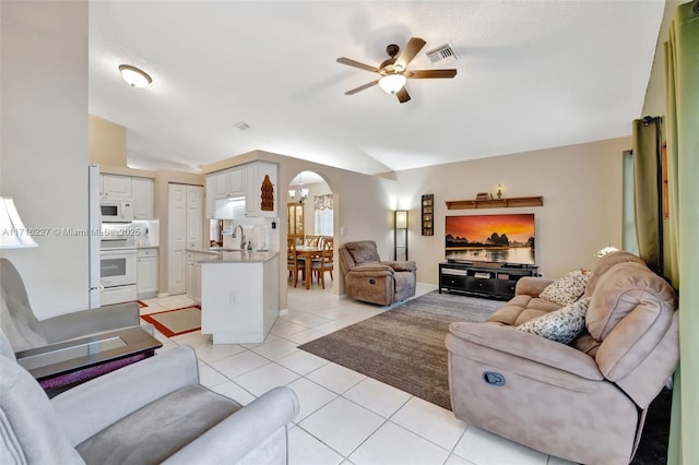 tiled living room featuring lofted ceiling, sink, and ceiling fan