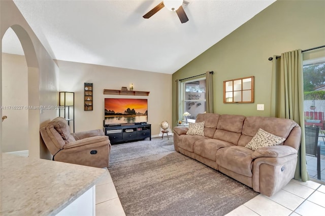 tiled living room with lofted ceiling and ceiling fan