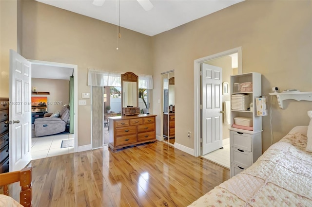 bedroom with a towering ceiling and light hardwood / wood-style flooring