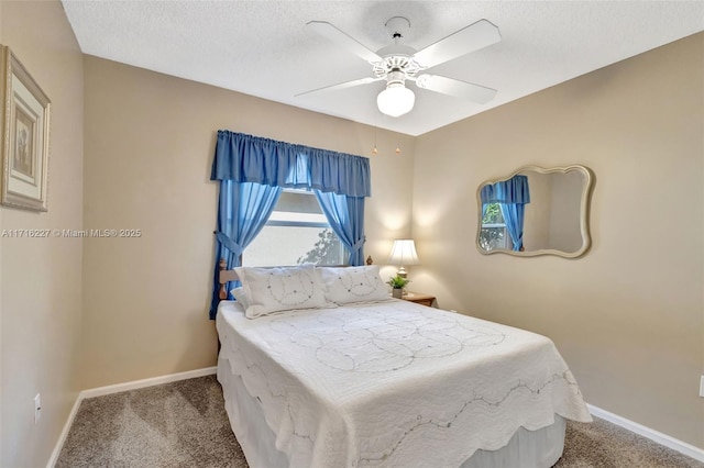 bedroom featuring ceiling fan, light colored carpet, and a textured ceiling