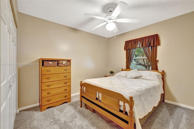 bedroom with ceiling fan, carpet flooring, and a textured ceiling