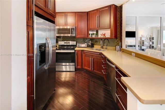 kitchen featuring tasteful backsplash, kitchen peninsula, sink, and appliances with stainless steel finishes