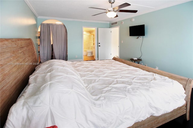 bedroom with ceiling fan, crown molding, and ensuite bath