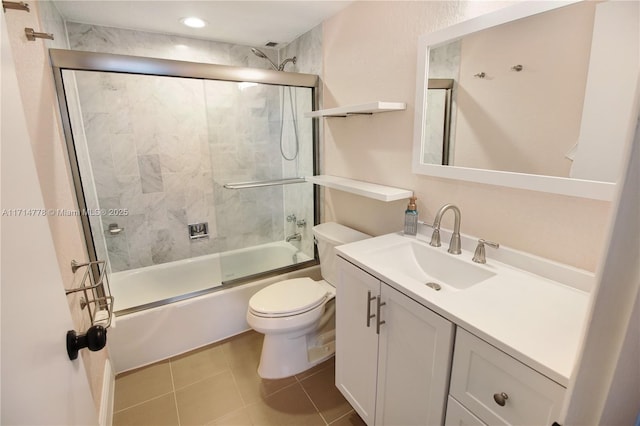 full bathroom with tile patterned floors, vanity, toilet, and bath / shower combo with glass door