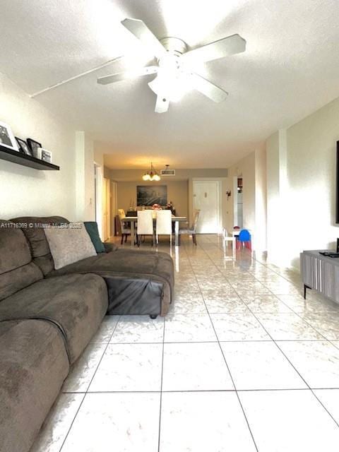 living room with ceiling fan and a textured ceiling