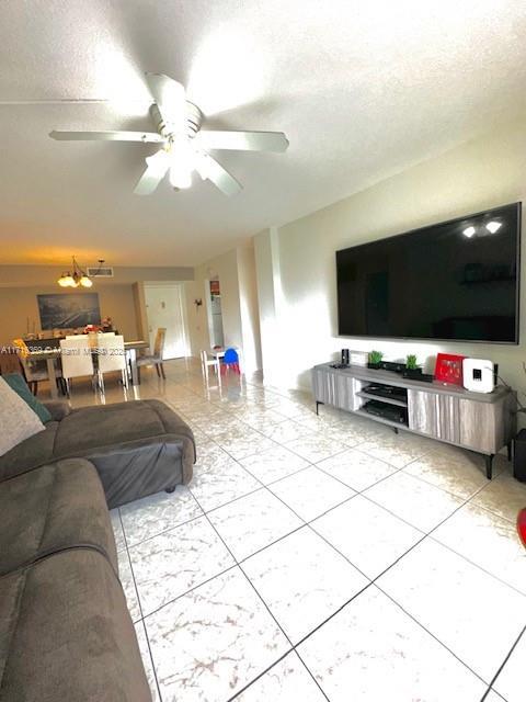 living room featuring a textured ceiling and ceiling fan